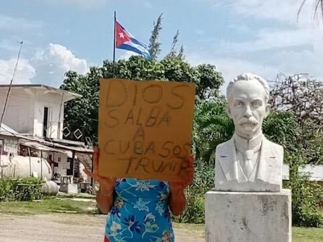 An anonymous person holds up a sign reading "God save Cuba, SOS Trump" in Los Pinos, Cuba, May 20, 2026.