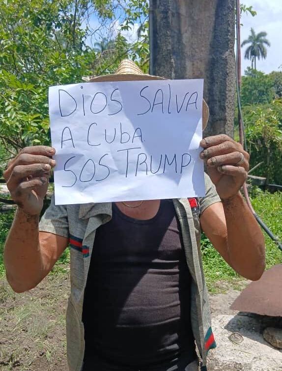 A person in Cuba holds up sign reading "God save Cuba, SOS Trump" in Pinar del Rio, Cuba, May 20, 2026.